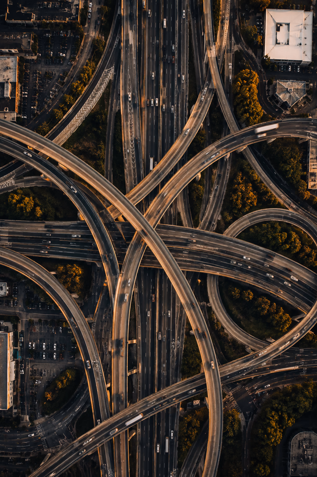 An aerial view of a complex multilane highway interchange surrounded by trees.